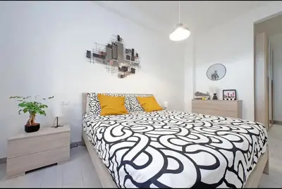 a bedroom with a black and white bed with yellow pillows at La Casa di Carmine in Rome