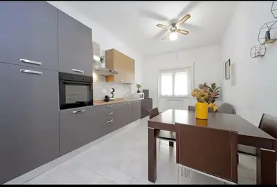 a kitchen with a table and a ceiling fan at La Casa di Carmine in Rome