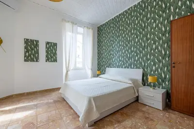 a bedroom with a bed and a green wall at San Lorenzo Residence two in Rome