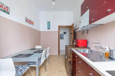 a kitchen with a sink and a table with chairs at San Lorenzo Residence two in Rome