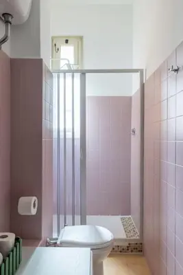 a pink bathroom with a toilet and a shower at San Lorenzo Residence two in Rome