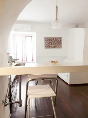 a kitchen with a white counter and a stool at Trastevere Art House in Rome