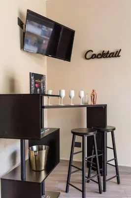 a bar with two stools and a tv on the wall at Charming Trastevere One in Rome
