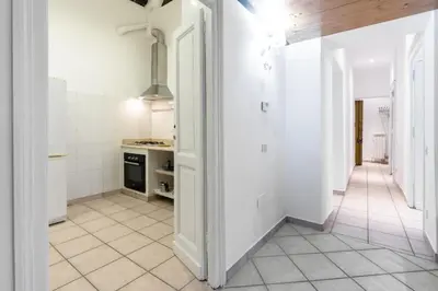 a kitchen with white walls and a white tiled floor at vatican apartment gianicolo in Rome