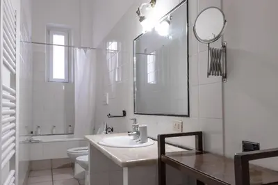 a bathroom with a sink and a toilet and a mirror at vatican apartment gianicolo in Rome