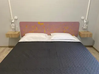 a bedroom with a bed with a purple headboard at Eureka Rooms in Rome