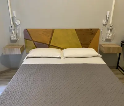 a bedroom with a large bed with a wooden headboard at Eureka Rooms in Rome