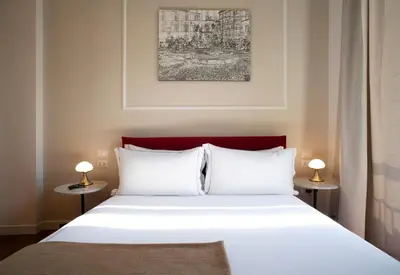 a bedroom with a white bed with two lamps at ElevenG in Rome
