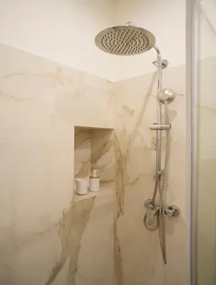 a shower in a bathroom with marble walls at ElevenG in Rome