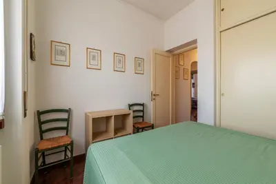 a bedroom with a green bed and two chairs at GuestHost - Flaminio Apartment panoramic view with terrace in Rome