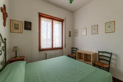 a bedroom with a green bed and two chairs at GuestHost - Flaminio Apartment panoramic view with terrace in Rome