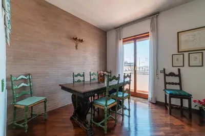 a dining room with a wooden table and chairs at GuestHost - Flaminio Apartment panoramic view with terrace in Rome
