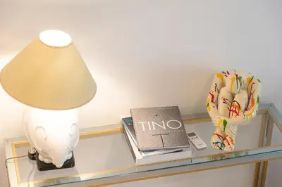 a lamp and a book on a glass shelf at Lovely Cozy Apartment Parioli in Rome