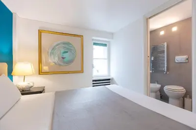 a white bedroom with a bed and a toilet at Lovely Cozy Apartment Parioli in Rome