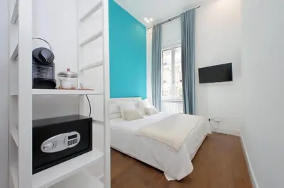 a white bedroom with a bed and a window at Fontana di Trevi dream home in Rome