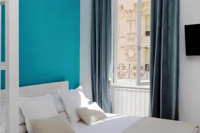a bedroom with a white bed and a window at Fontana di Trevi dream home in Rome