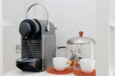 a coffee maker and two cups on a counter at Fontana di Trevi dream home in Rome