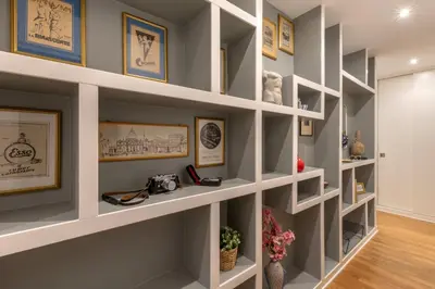 a room with white shelves with paintings and pictures at St.Peter's1928 in Rome