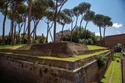 an old brick wall with trees in the background at St.Peter's1928 in Rome