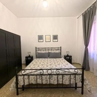 a bedroom with a bed with a metal bed frame at La casetta ai colli - Vicino alla Metro A in Rome