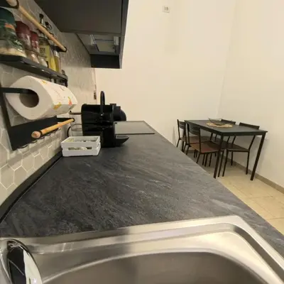 a kitchen with a sink and a table with chairs at La casetta ai colli - Vicino alla Metro A in Rome