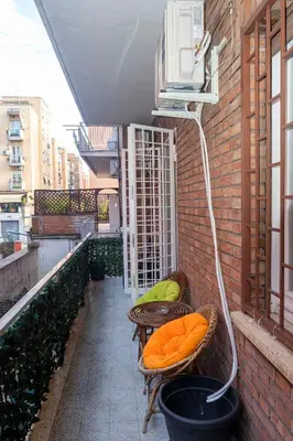 a balcony with two chairs and a heater on a building at La casetta ai colli - Vicino alla Metro A in Rome