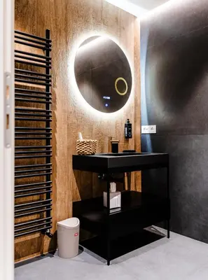 a bathroom with a black vanity and a round mirror at La Dolce Vita Luxury Apartment in Rome