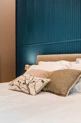 a bed with white sheets and a blue wall at La Dolce Vita Luxury Apartment in Rome