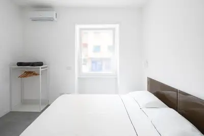 a white bedroom with a bed and a window at Claudio Vaticano Home in Rome