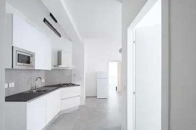 a white kitchen with a sink and a refrigerator at Claudio Vaticano Home in Rome