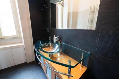 a bathroom with a glass sink and a mirror at Casa Aosta in Rome