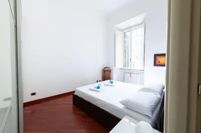 a bedroom with a white bed and a window at Casa Aosta in Rome