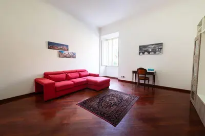 a living room with a red couch and a table at Casa Aosta in Rome
