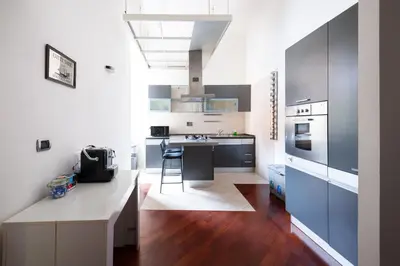 a kitchen with blue cabinets and a table in it at Casa Aosta in Rome
