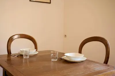 a wooden table with two chairs and plates and glasses at Riboty 21 in Rome
