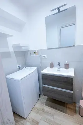 a white bathroom with a sink and a mirror at The Little Big House in Rome