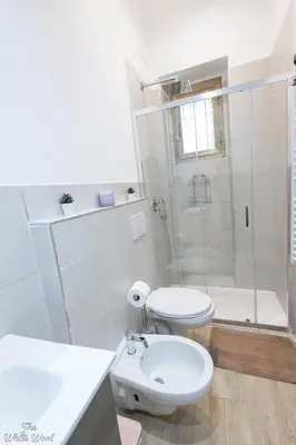 a white bathroom with a toilet and a shower at The Little Big House in Rome