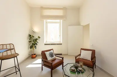 a living room with two chairs and a glass table at Lovely Cozy Nazionale 4 in Rome