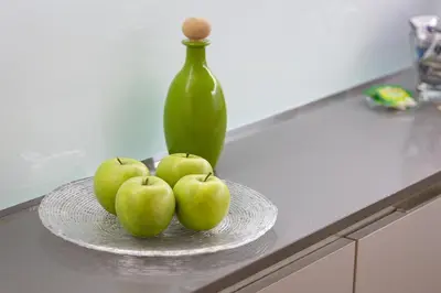 a plate of apples on a counter with a green vase at Lovely Cozy Nazionale 4 in Rome