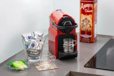 a coffee maker sitting on a counter with glasses at Lovely Cozy Nazionale 4 in Rome