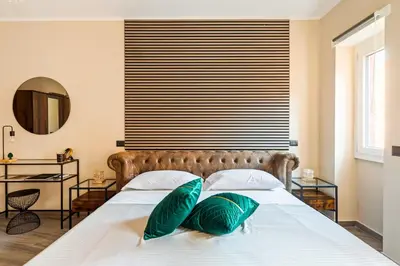 a bedroom with a large bed with green pillows at Charming Trastevere Two in Rome