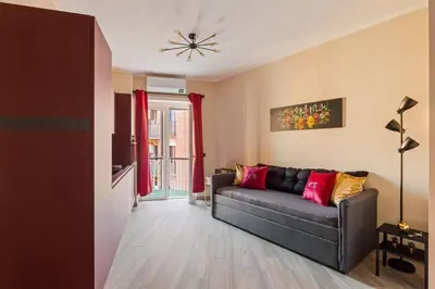 a living room with a black couch and red pillows at Charming Trastevere Two in Rome