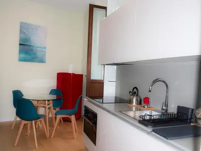 a kitchen with a table and chairs and a counter top at Barberini Bright Apartment in Rome