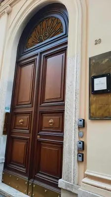 a large wooden door on the side of a building at Barberini Bright Apartment in Rome