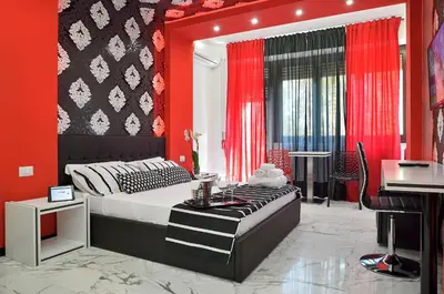 a bedroom with a bed and a red wall at Black & White G&G in Rome