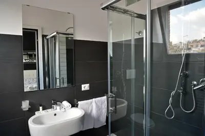 a bathroom with a sink and a glass shower at Black & White G&G in Rome