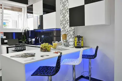 a kitchen with a white counter and blue chairs at Black & White G&G in Rome