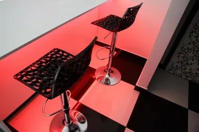 two chairs sitting on a table with red lighting at Black & White G&G in Rome