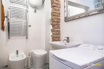 a bathroom with a sink and a toilet and a mirror at Mecenate Apartment Fori Imperiali in Rome