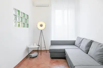 a living room with a couch and a floor lamp at Vinylogy Apartment 5to Piano in Rome